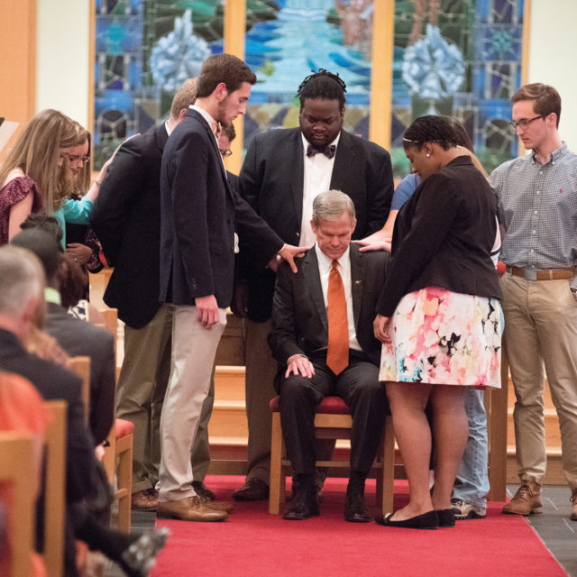 image of dr. creed praying with students