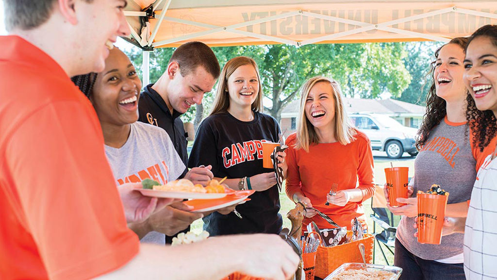 students laugh at homecoming tailgate