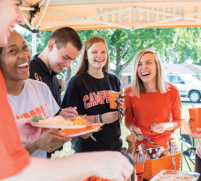 students laugh at homecoming tailgate