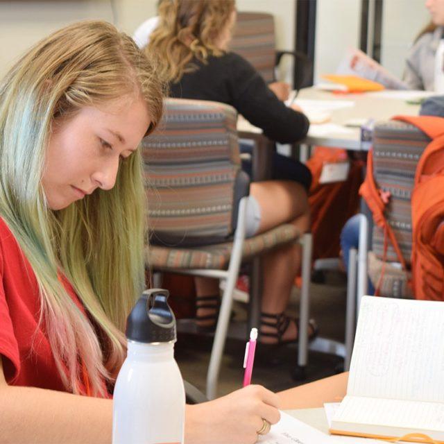 Girl takes notes in classroom