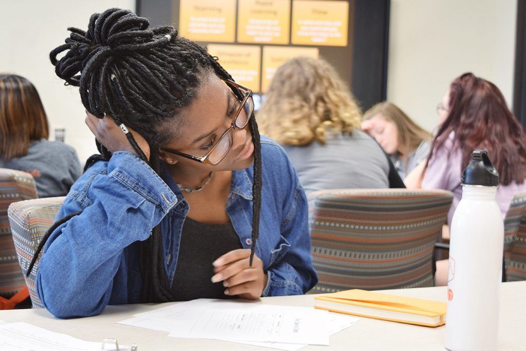 Girl studies paper at desk