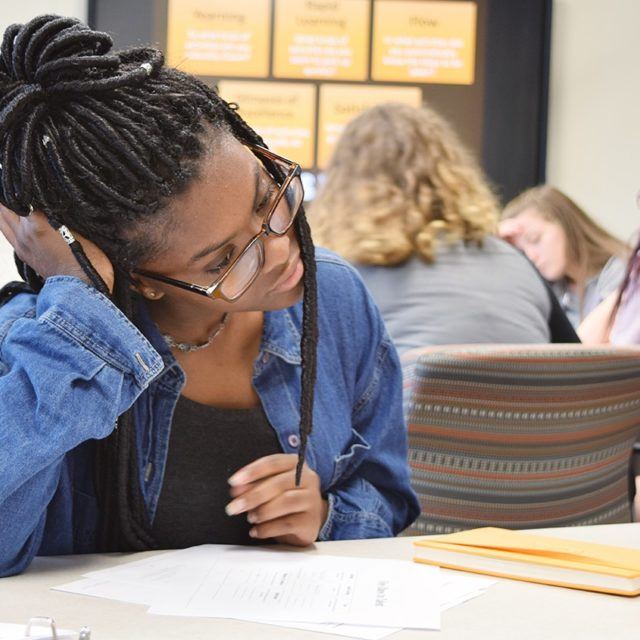 Girl studies paper at desk