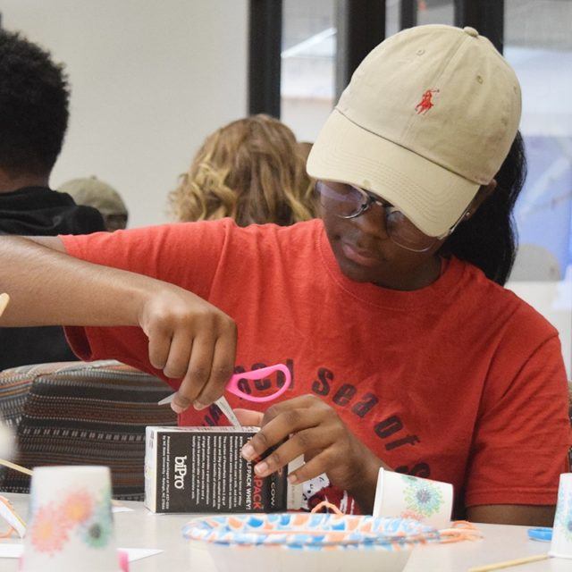 Girl works on craft at table