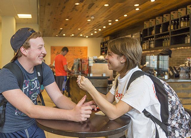 Two students catch up at the Starbucks located inside the Wiggins Memorial Library.
