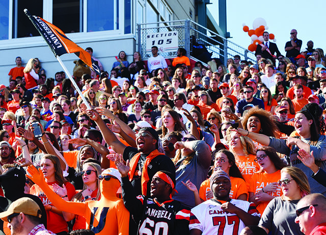 Students cheer on the football team during homecoming.