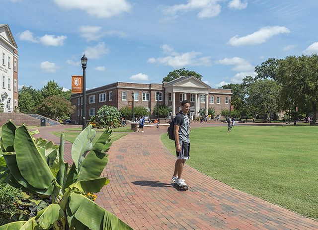 A student makes his way to class on a skateboard.