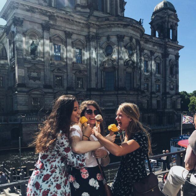 Three girls eating ice cream together on a river boat in Berlin