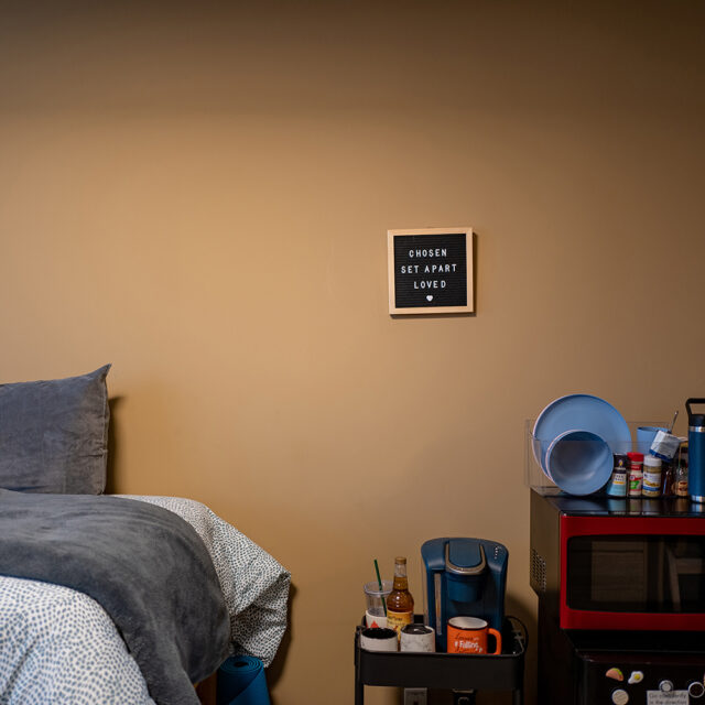 Room photo inside Pat Barker Hall. It features a close-up of a sign that reads Chosen, Set Apart, Loved.