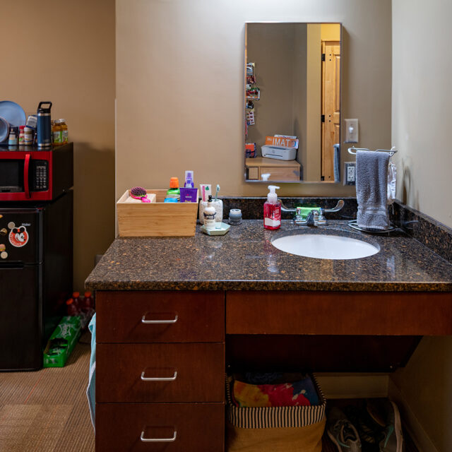 Interior of Pat Parker Hall room including a vanity with sink and mirror.