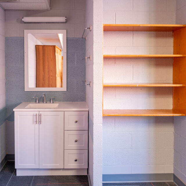 Interior of Powell Hall including a built-in bookshelf and vanity with sink and mirror.