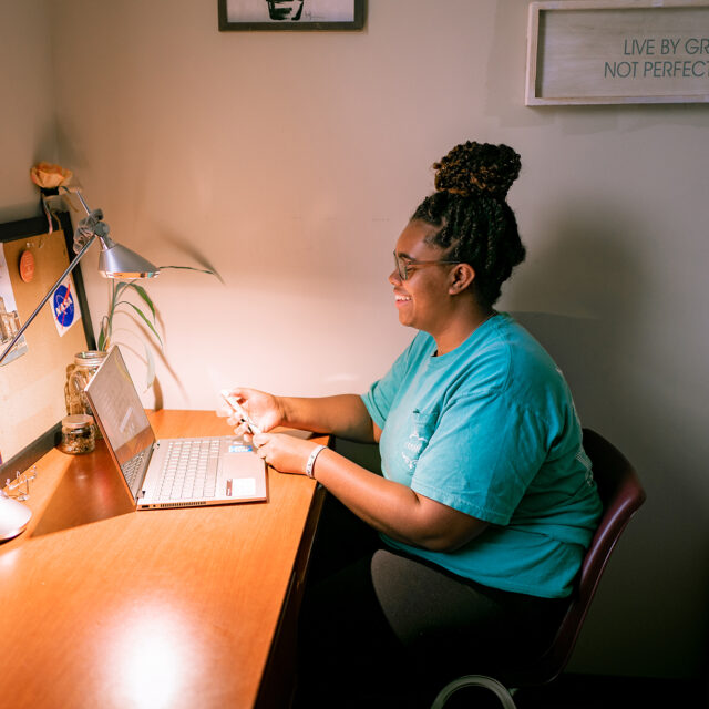 Image of a female student studying in her room in Bob Barker Hall.
