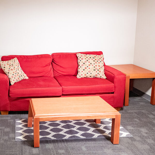 Image of a common area featuring a sofa and coffee table in Bob Barker Hall.