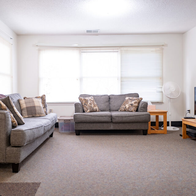 Image of a living room including comfortable sofa inside a Faculty Memorial Commons apartment