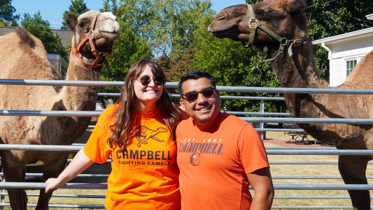Students standing in front of two camels posing for picture