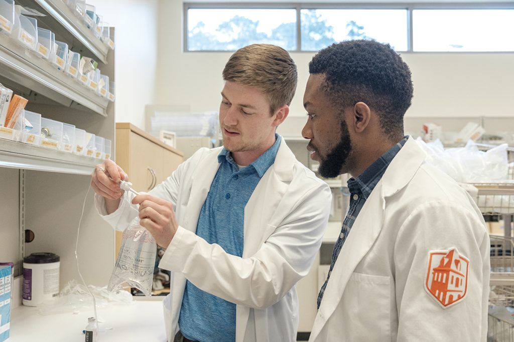 Resident and student look at IV bag