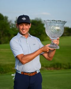 alumni with trophy