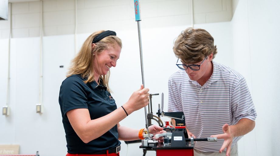 student working on club repair equipment