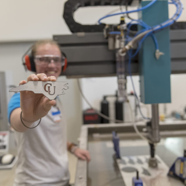 Student holding North Carolina silhoette cut on water jet