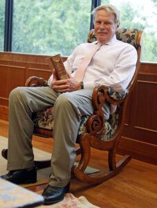 Photo of Dean J. Rich Leonard sitting in former U.S. Supreme Court Justice John Marshall's chair, which has been donated to the law school.