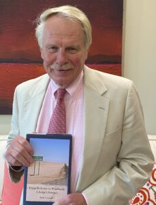 Photo of Dean Leonard holding his book, A Judge's Journey