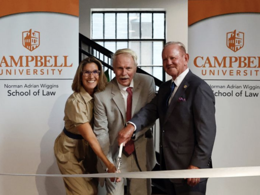 Photo of Benji Jones, Dean J. Rich Leonard and Terry Hutchens cutting a white ribbon for the new Hutchens Business Law Clinic grand opening!
