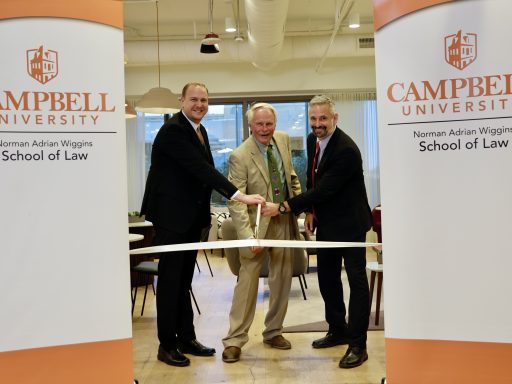 Photo of the Veterans Law Clinic Ribbon Cutting with Richard Waugaman '09, '12, Sebastian Kielmanovich, Dean J. Rich Leonard cutting a ribbon in The Commons