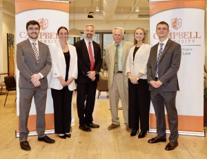 Photo of four Campbell Law students with Dean Leonard and Veterans Legal Clinic Director Sebastian Kielmanovich