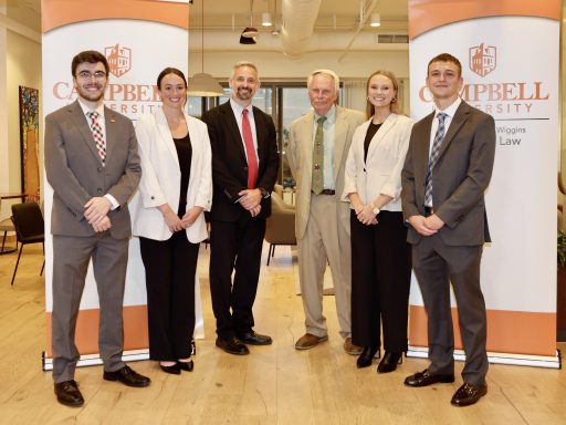 Photo of four Campbell Law students with Dean Leonard and Clinic Director Sebastian Kielmanovich