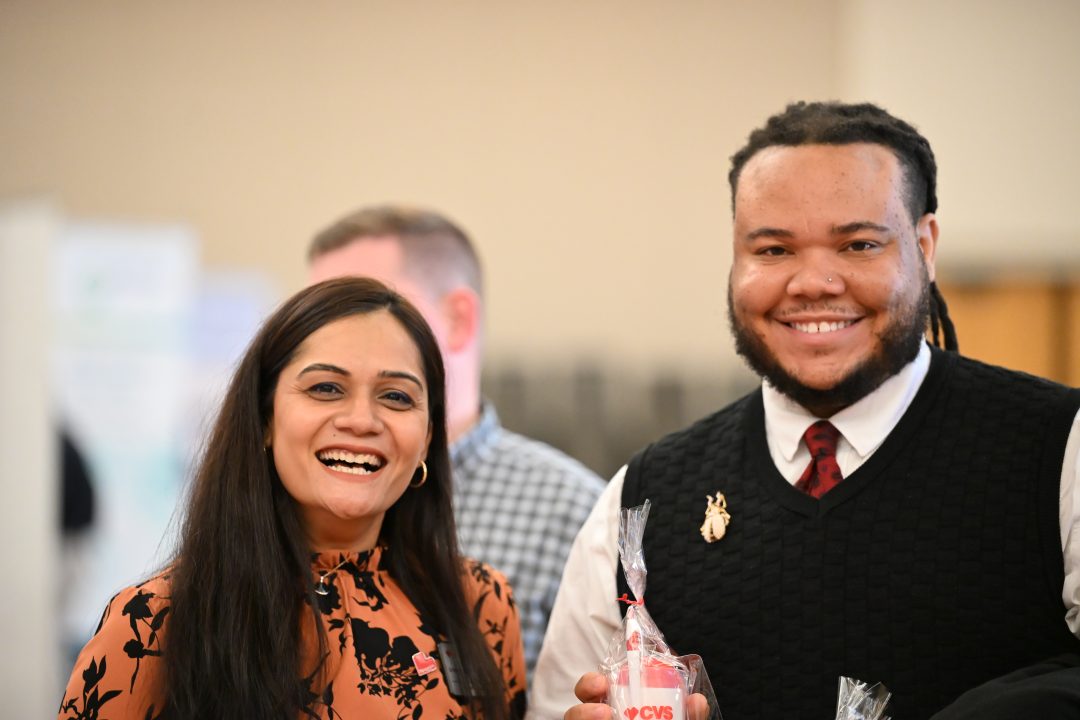 Preceptor and student smile at camera.