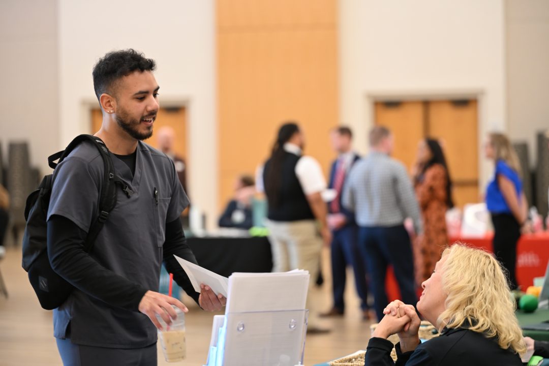 Male nursing student talking with potential employer.
