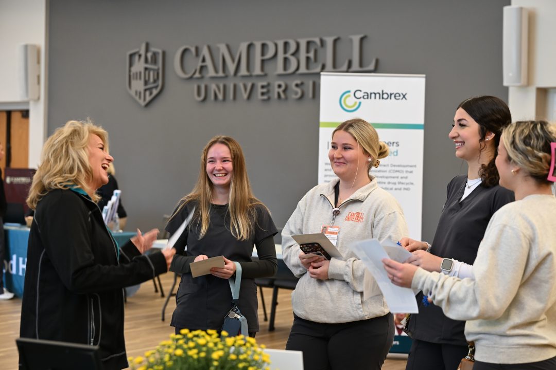 Nursing students in a group talking with employer.