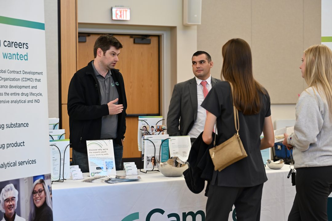 Pharmaceutical Sciences alumnus talking with current students.