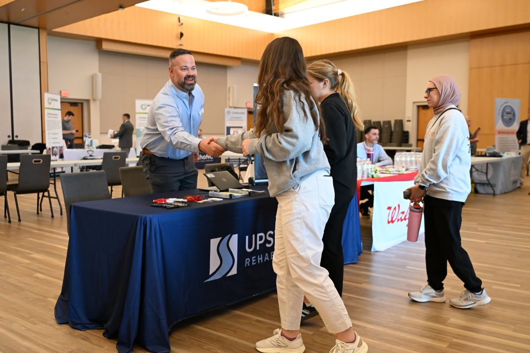 Potential employer shaking hands with student.