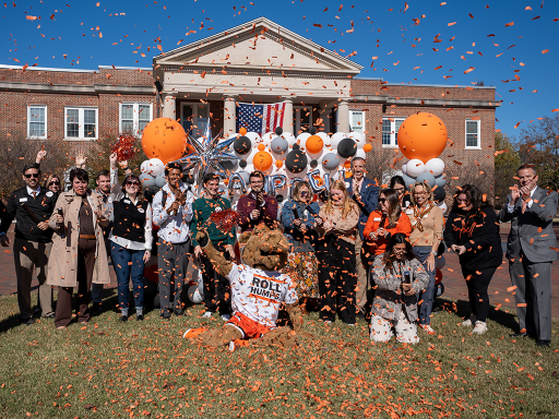 A group of staff, students and faculty posing for a Campbell Giving Day celebration photo with confetti and balloons