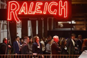 Photo of student and employers gathered at 2025 Career Night at Union Station under neon Raleigh sign i