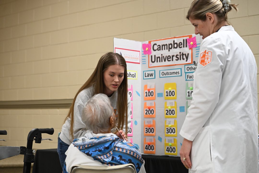Student and faculty member counsel a participant.