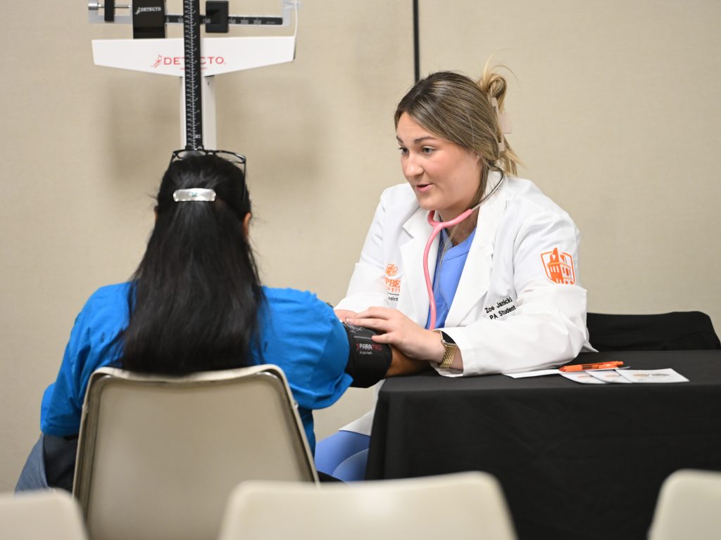 PA student taking blood pressure.