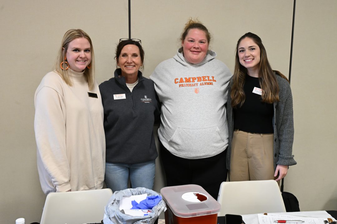 Faculty, alumni and students standing togther.