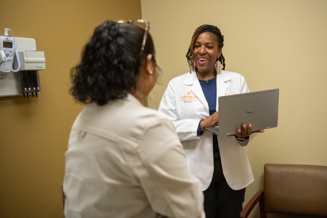 Pharmacy student talking with patient in clinic.