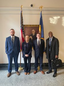 Photo of Team 1 -- Jessica Griffin ‘26, Christian Ray ‘26 and Justin Booker ‘26 with Coach Justin Lockett ‘22