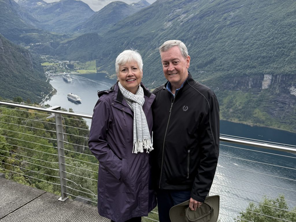 Photo of Judge Jane Gray '79 and her husband, Frank Gray, standing in front of a Norwegian Fjord.