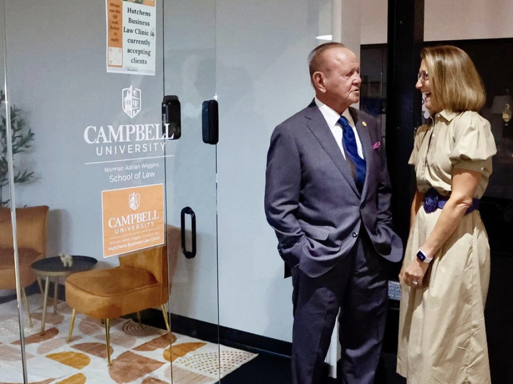 Photo of Terry Hutchens and Clinical Professor Benji Jones standing outside Hutchens Business Law Clinic in Raleigh Founded.