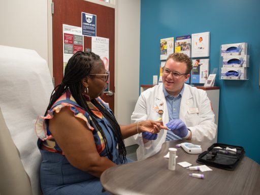 Pharmacy student working with patient in clinic.