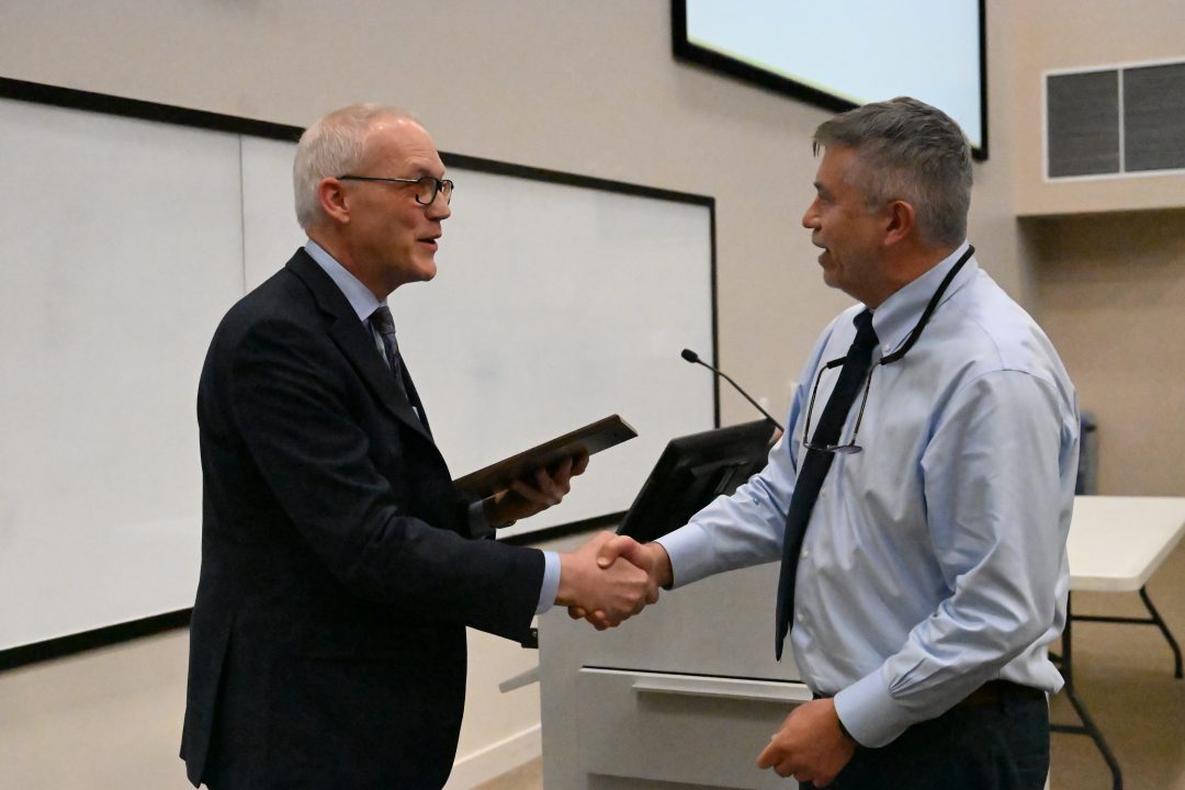 Dean Mercer shakes Dr. Pulgar's hand when presenting the award.