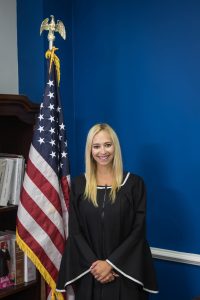 Photo of Judge Angelica Chavis McIntyre '13 posing in front of U.S. flag