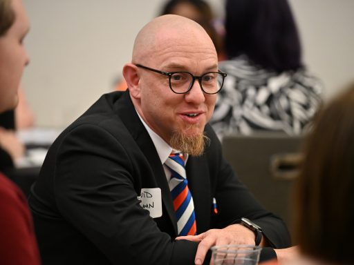 Dr. Tillman leaning in to speak with group at table