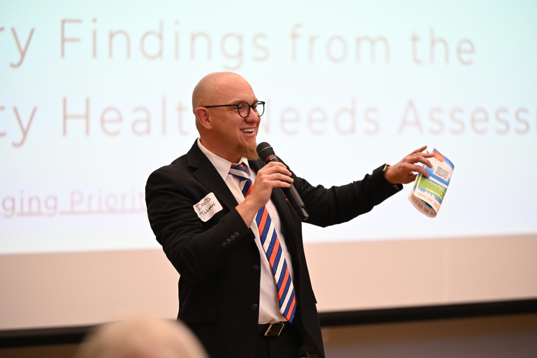 Tillman speaking at event holding microphone