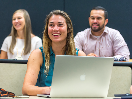 Campbell student smiling in class room with laptop open