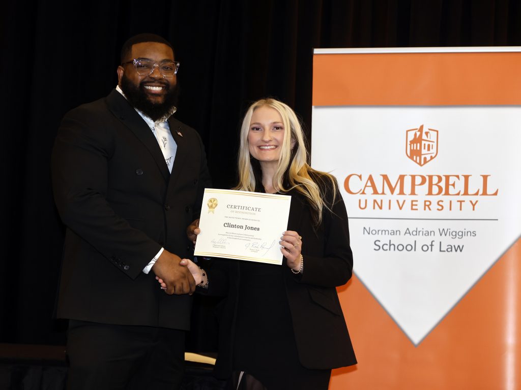 Photo of Campbell Law students Clinton Jones '28 and Jessica Griffin '26 posing in front of Campbell Law banner at 2026 Law Awards Banquet