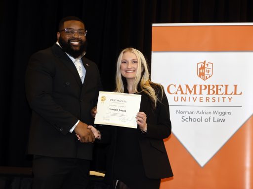Photo of Campbell Law students Clinton Jones '28 and Jessica Griffin '26 posing in front of Campbell Law banner at 2026 Law Awards Banquet